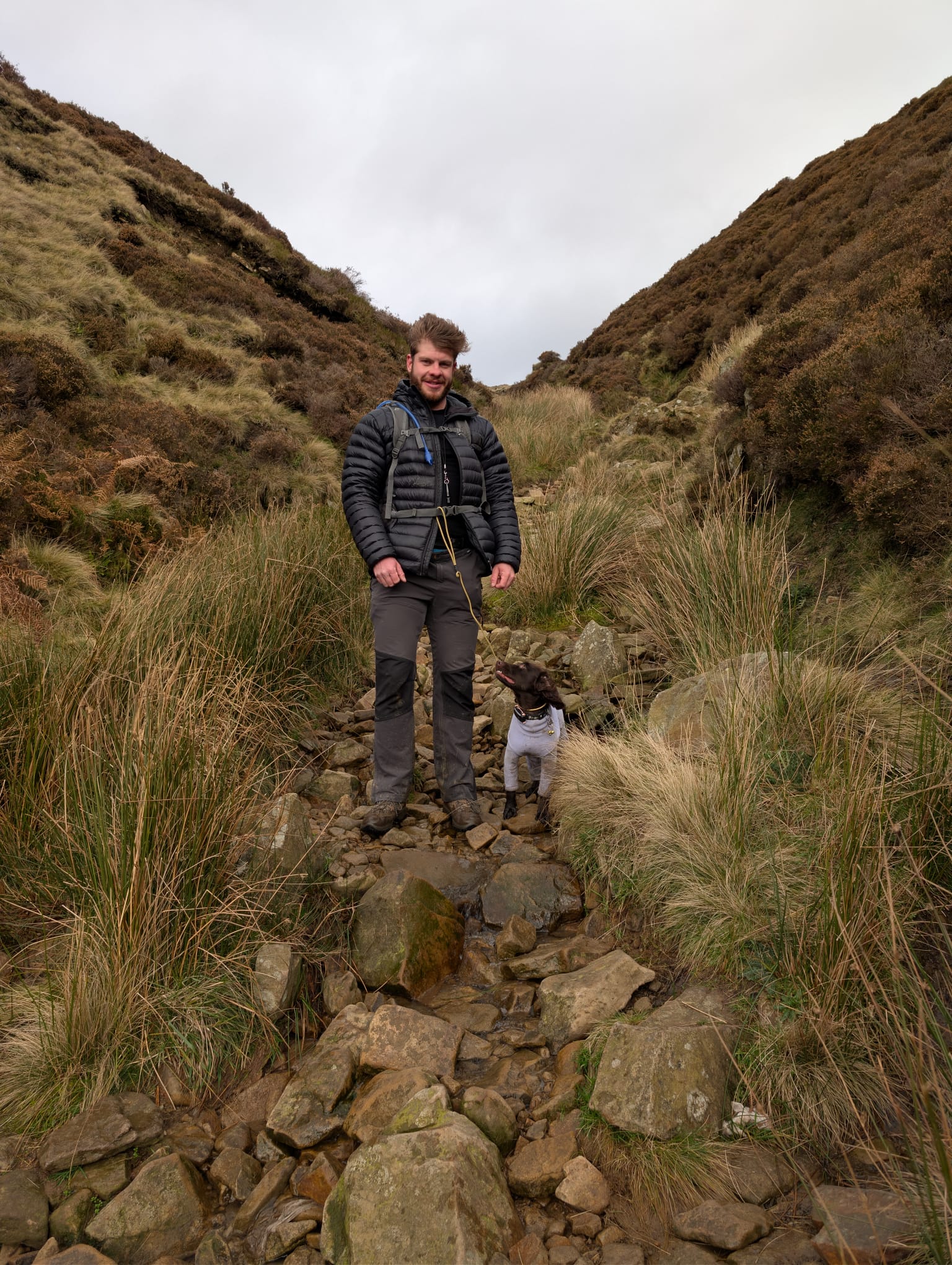 James on a demanding Peak District trail with a focused, leashed dog at heel